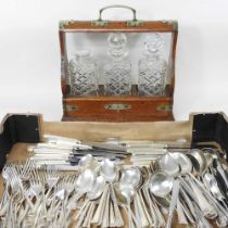 An early 20th century tantalus, together with a collection of silver plated cutlery