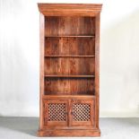 An Eastern hardwood standing open bookcase, with grille doors below 100w x 45d x 206h cm