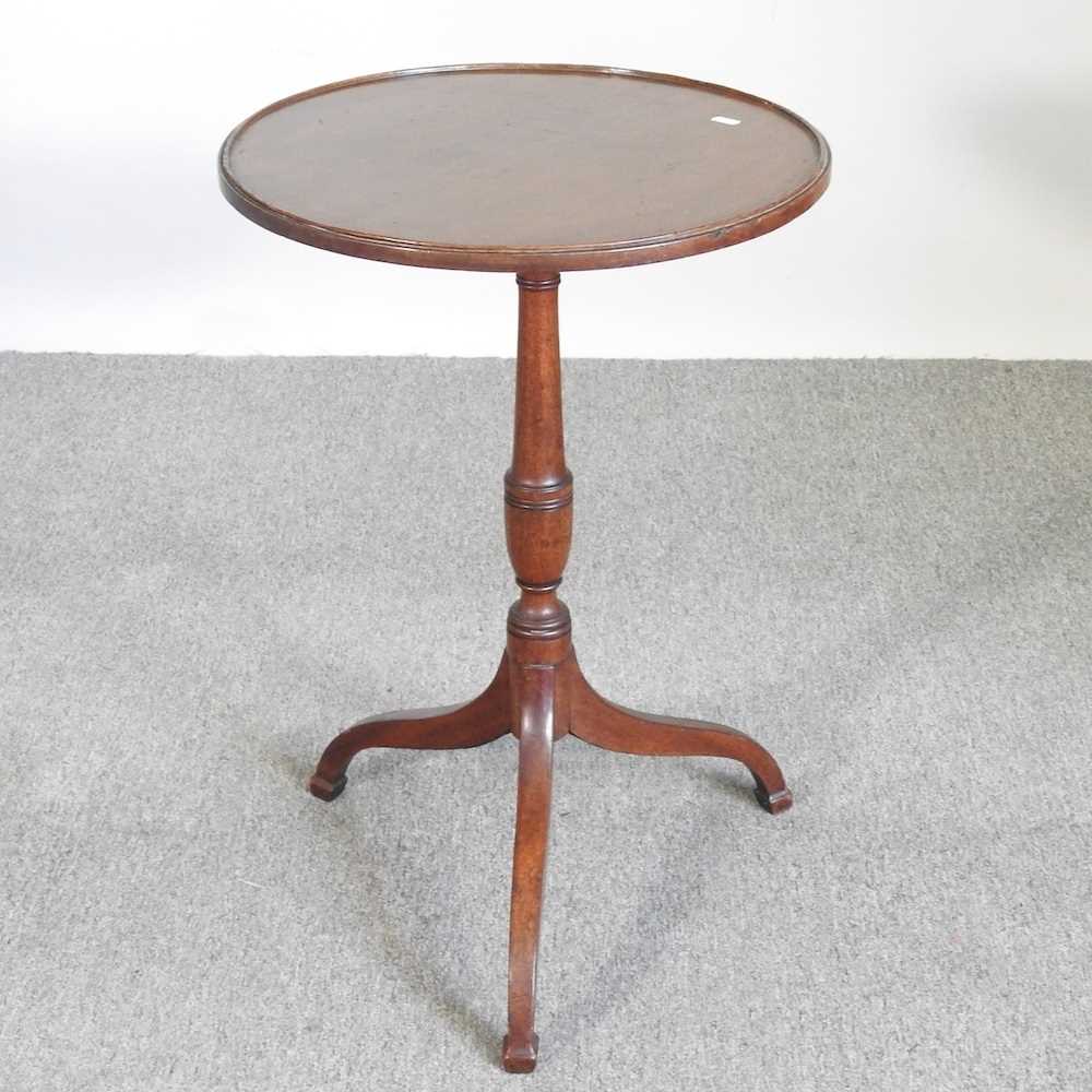 A George V mahogany wine table, with a hinged circular top, on a tripod base, stamped GV to the