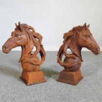 A pair of rusted metal horse head gatepost finials, on balls (2)