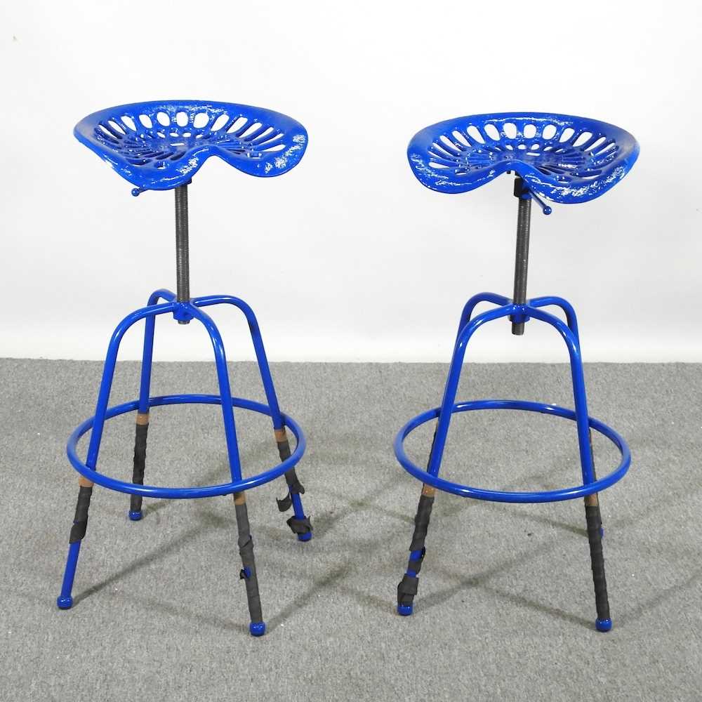 A pair of blue painted metal tractor seat bar stools (2)