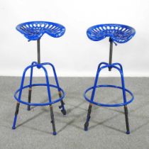 A pair of blue painted metal tractor seat bar stools (2)