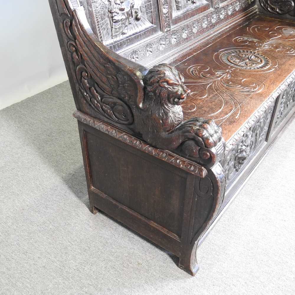 A 19th century Dutch heavily carved dark oak box settle, the panelled back carved with tavern - Image 4 of 6