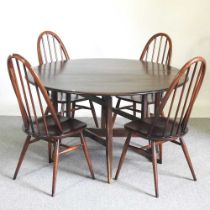 An Ercol dark elm drop leaf dining table, together with a set of four hoop back dining chairs (5)