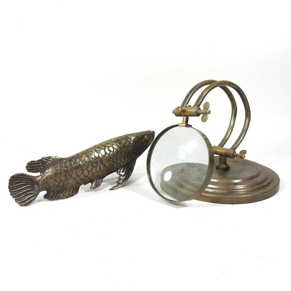 A bronze model of a carp, 28cm long, together with a desk magnifying glass (2)