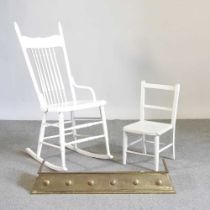A white painted rocking chair, together with a child's chair and an Art Nouveau brass fender, 97cm