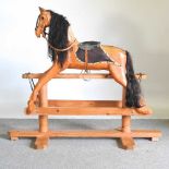 A carved pine vintage rocking horse, on a trestle base, 131cm high overall 150w x 60d x 130h cm