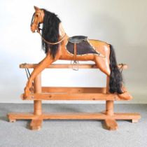 A carved pine vintage rocking horse, on a trestle base, 131cm high overall 150w x 60d x 130h cm