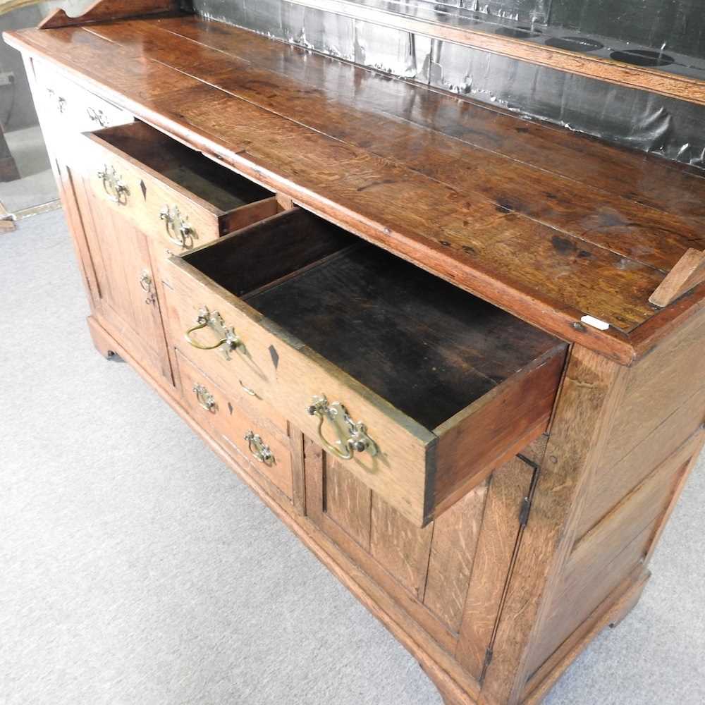 An 18th century Welsh oak dresser, having a boarded back, over an arrangement of short drawers and - Image 4 of 7