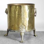 An early 20th century brass log bin, on paw feet 37w x 46h cm