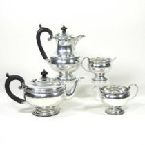 An early 20th century silver four piece tea service, of circular shape, with ebonised handles and