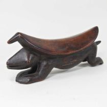 An African carved wooden zoomorphic pillow/head rest, of curved shape, on a reptile base, 32cm