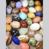A collection of various polished hardstone eggs