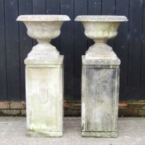 A pair of large cast stone garden urns, each on a plinth base, 119cm high (2)