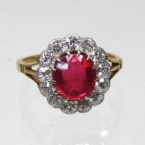 A ruby and diamond cluster ring, the central cushion cut stone approximatey 9 x 8mm, surrounded by