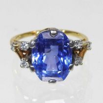 A large tanzanite and diamond ring, the central oval cut stone approximately 10 x 12mm, flanked by