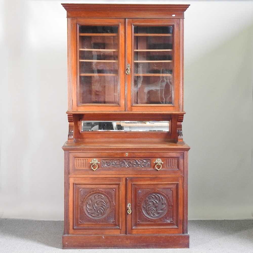 A Victorian walnut cabinet bookcase, with a mirrored back 124w x 51d x 235h cm