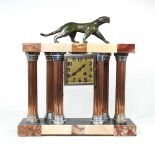 An Art Deco marble mantel clock, surmounted by a bronzed puma, 42cm wide