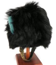 Irish Guards Busby black, long fur busby.  The right side with light blue, short horsehair plume.