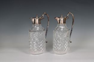 A pair of 20th century clear cut glass decanters / claret jugs with silver plated lids and handles