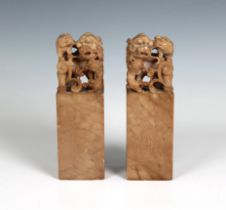 A pair Chinese carved soapstone desk seals surmounted by a lion / Fo dog with cub, Chinese script to