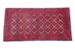 A Turkmen rug with repeating medallion main field flanked by meandering and saw-tooth borders, 71¾ x