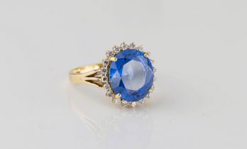 An 18ct yellow gold, sapphire and diamond cluster ring the cornflower blue, oval cut sapphire