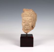 A South-east Asian carved sandstone Buddha head fragment possibly Khmer, mounted for display,