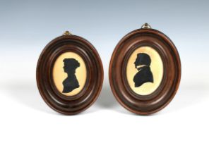 A pair of Georgian silhouettes on paper, depicting a lady and gentleman, each frame in deep wooden