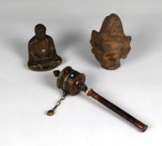 A Tibetan prayer wheel with cabochon decoration, together with a heavy stone Buddha head and