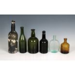 A collection of antique bottles to include a dark green / black bottle, 8in. (20.3cm.), together