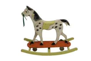 A 1950's combined wooden rocking horse and pull toy hand painted with wooden wheels and butterfly