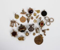 A collection of unmarked yellow metal charms comprising faux coins, seals, hat, horn, football,