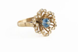 An 18ct yellow gold zircon and diamond dress ring the central round cut blue zircon surrounded by