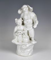 A Chinese porcelain blanc-de-chine figural group of Buddha and attendant the Buddha modelled