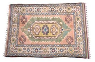 A late 20th century Turkish rug the lozenge medallion with three gols, on a pale green field, the