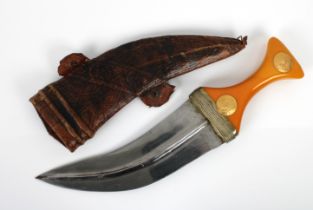 A Middle Eastern Jambiya dagger with yellow metal mounted amber colour bakelite handle,