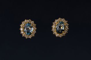 A pair of aquamarine and diamond cluster ear studs The central oval-shaped aquamarines in a surround