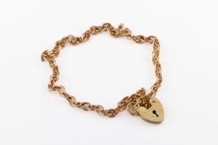 A 9ct yellow gold charm bracelet The delicate charm bracelet of cable chain with heart shaped lock.