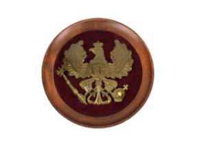 A Prussian enlisted mans pickelhaube helmet plate the plate attached to circular oak frame, maroon