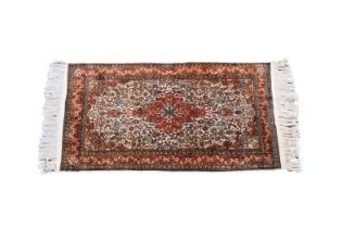 A small Kashan style silk rug the central floral medallion with matching spandrels on an ivory