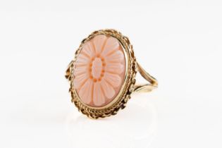 A 9ct yellow gold and coral ring The coral carved in floral daisy design, within a decorative