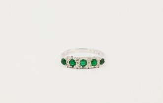 An 18ct white gold, emerald and diamond half hoop featuring 5 round cut emeralds with chip diamond