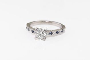 A platinum, sapphire and diamond engagement ring the principal, brilliant cut diamond weighing