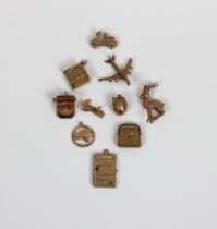A collection of gold charms comprising a set of skis, 18ct, 0.7g; Canada maple leaf, 14k, 1.3g,