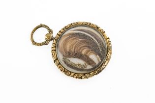 A gold plated locket with hair The gold plated locket engraved, with engine turned decoration and