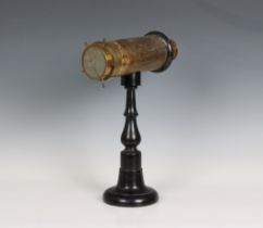 A Victorian table top kaleidoscope on a turned ebonised stand, 13½in. (34.3cm.) high. * Brass with