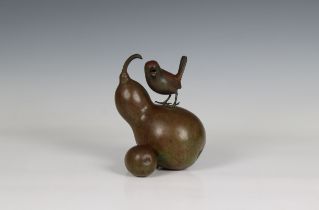 A Japanese green patinated bronze of a bird standing on two gourd Meiji period (1868-1912), modelled