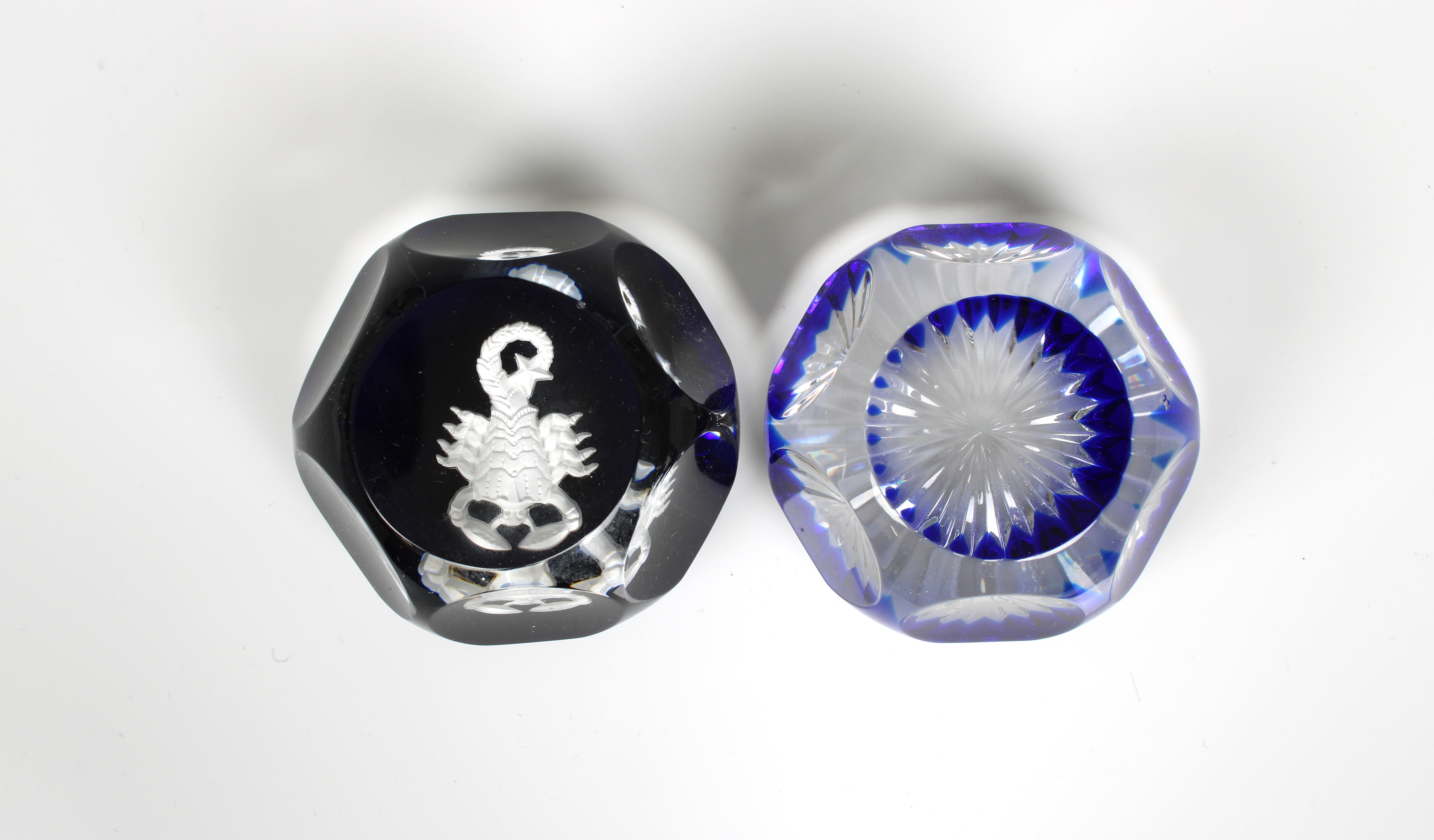 A Baccarat Zodiac Scorpion Sulphide Paperweight clear glass facet cut on a blue ground enclosing a