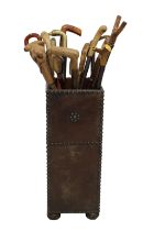 A collection of walking sticks / canes of varying types, together with a leather clad stick stand,